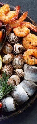 Seafood charcuterie platter board with shrimp, oysters, fish and octopus on black background. Top view, close up